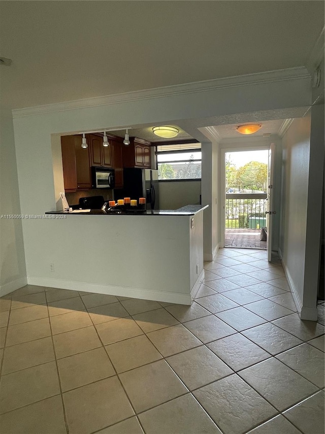 kitchen featuring light tile floors, kitchen peninsula, black fridge, and ornamental molding