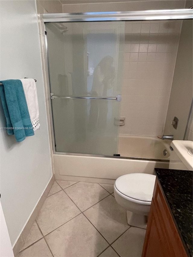 full bathroom featuring toilet, shower / bath combination with glass door, and tile flooring