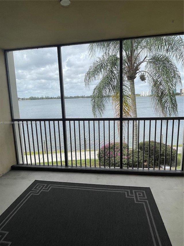 unfurnished sunroom featuring a water view