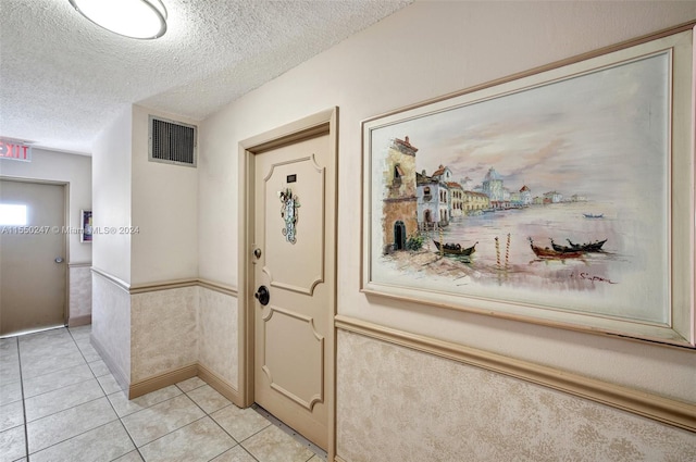 entryway with a textured ceiling and light tile floors