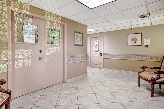 tiled foyer entrance featuring a drop ceiling