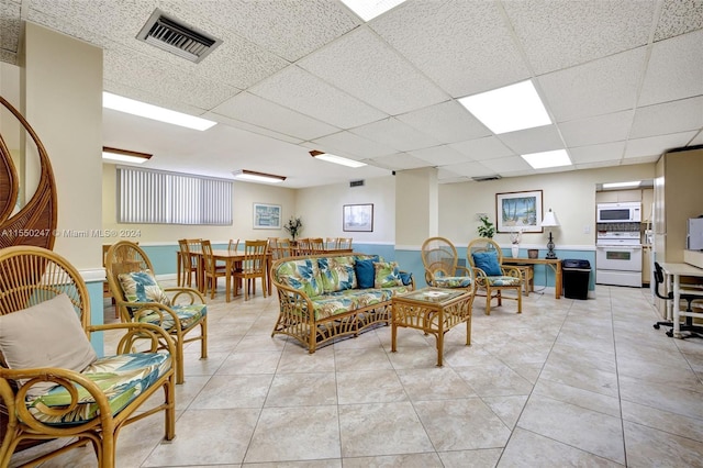 tiled living room with a paneled ceiling