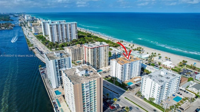 birds eye view of property with a beach view and a water view