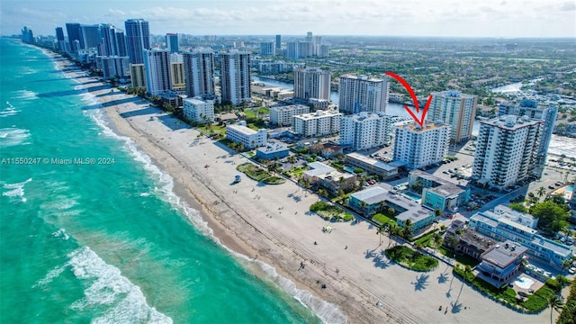 drone / aerial view featuring a beach view and a water view