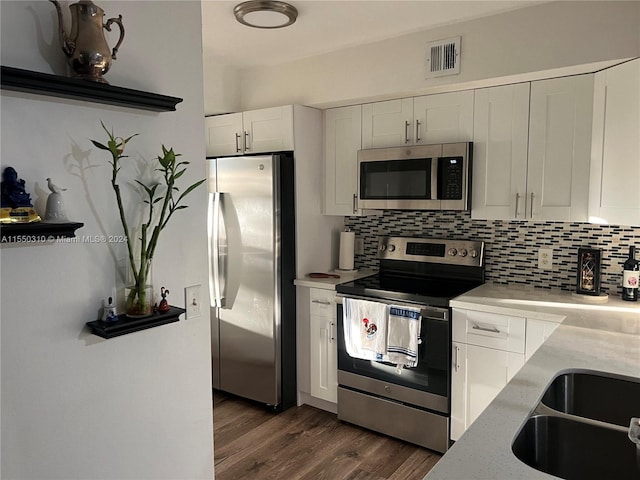 kitchen featuring white cabinetry, backsplash, dark wood-type flooring, and stainless steel appliances