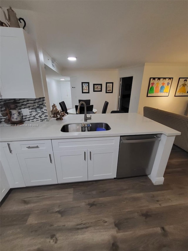 kitchen with stainless steel dishwasher, kitchen peninsula, white cabinets, dark hardwood / wood-style floors, and sink