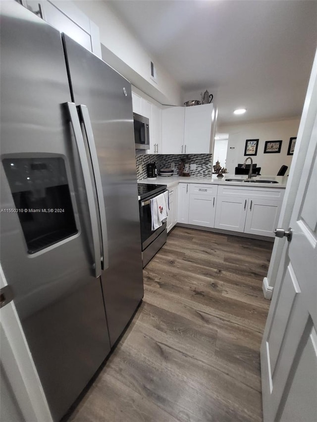 kitchen with sink, dark hardwood / wood-style flooring, stainless steel appliances, tasteful backsplash, and white cabinetry