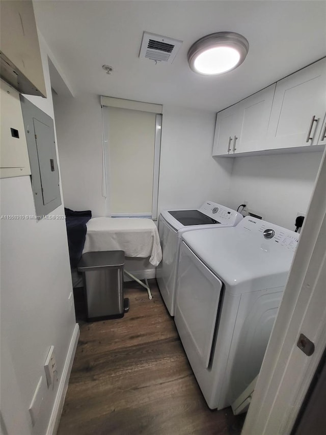 laundry area featuring cabinets, washer and dryer, and dark hardwood / wood-style flooring