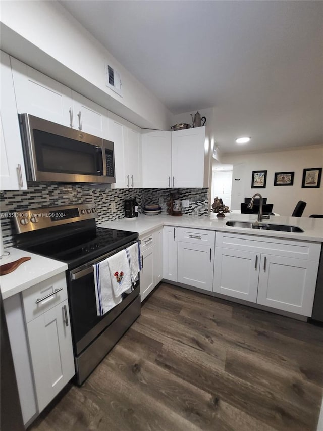 kitchen featuring appliances with stainless steel finishes, white cabinetry, dark hardwood / wood-style floors, and sink