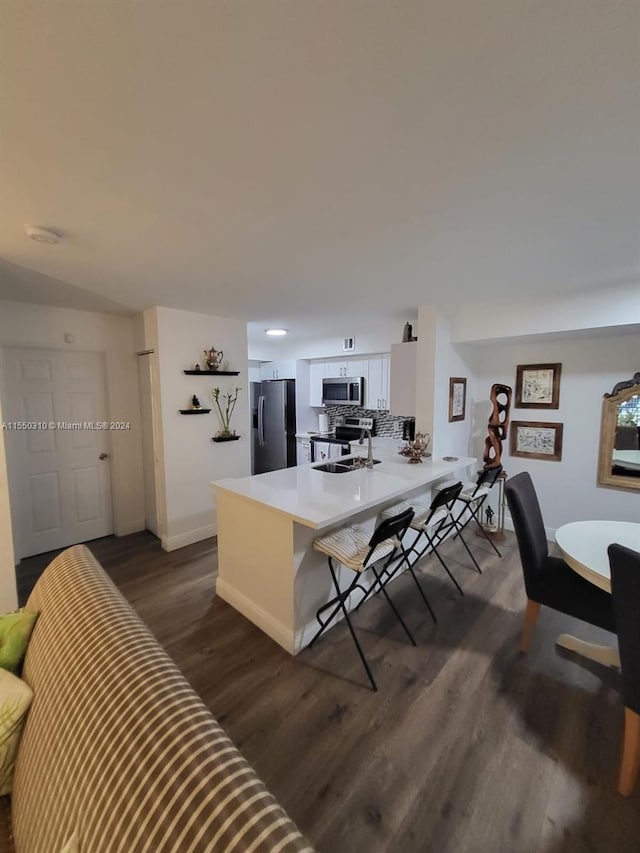 living room featuring sink and dark hardwood / wood-style flooring