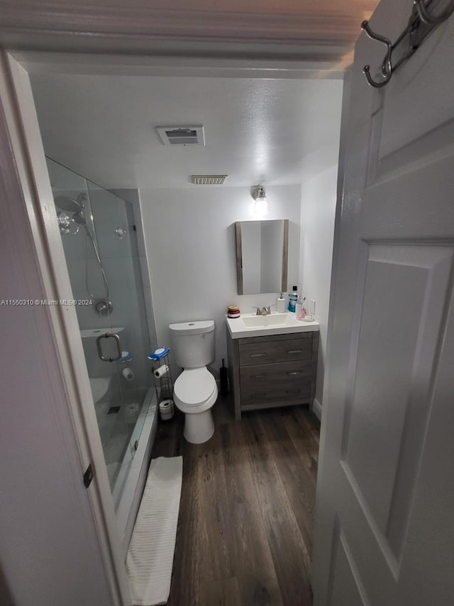 full bathroom featuring vanity, toilet, bath / shower combo with glass door, and hardwood / wood-style flooring