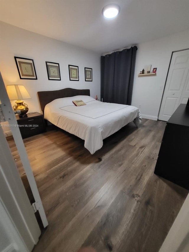 bedroom with dark wood-type flooring