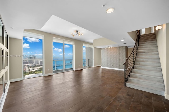 interior space featuring a water view, dark wood-type flooring, and a chandelier