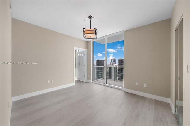 unfurnished room featuring light hardwood / wood-style flooring and expansive windows