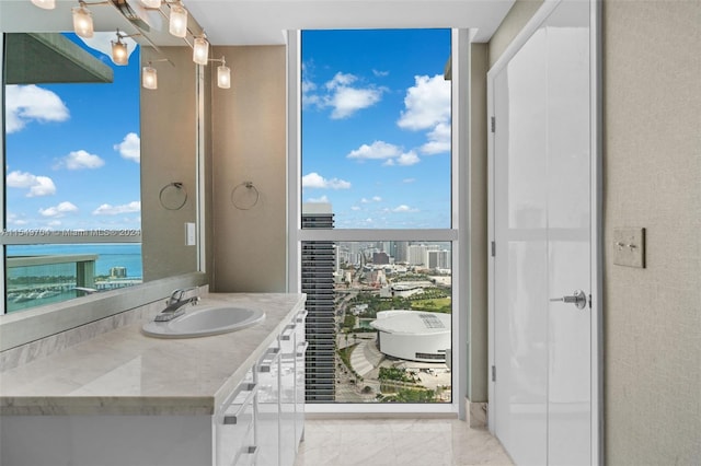 bathroom featuring a water view, tile flooring, vanity, and a healthy amount of sunlight