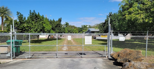 view of gate with a yard