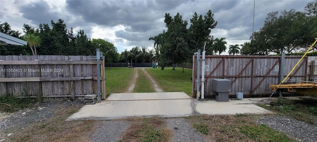 view of gate with a lawn