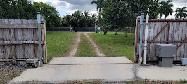 view of gate with a lawn