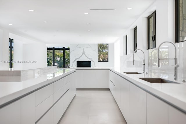 kitchen with white cabinetry, sink, and tasteful backsplash