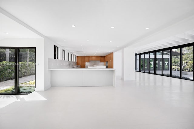 kitchen with tasteful backsplash, light tile floors, and kitchen peninsula