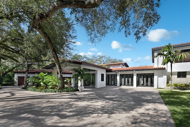 mediterranean / spanish-style home featuring a garage and french doors