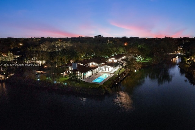 aerial view at dusk featuring a water view