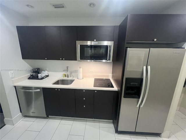 kitchen with light tile patterned floors, appliances with stainless steel finishes, and sink