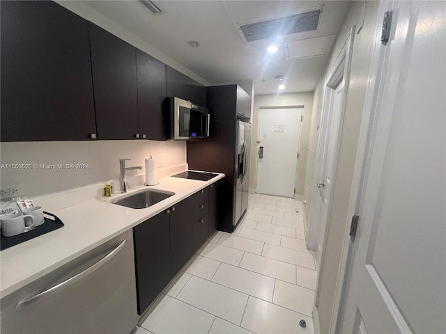 kitchen with sink, stainless steel appliances, and light tile patterned floors