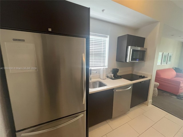 kitchen with stainless steel appliances, sink, and light tile patterned floors