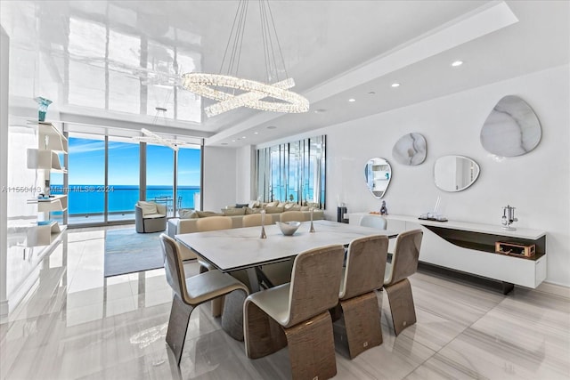 dining room featuring light tile floors, a raised ceiling, a notable chandelier, and a wealth of natural light