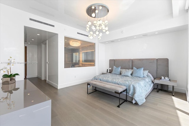 bedroom with a chandelier and light wood-type flooring