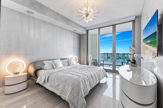 bedroom with a water view, a notable chandelier, a wall of windows, and access to exterior