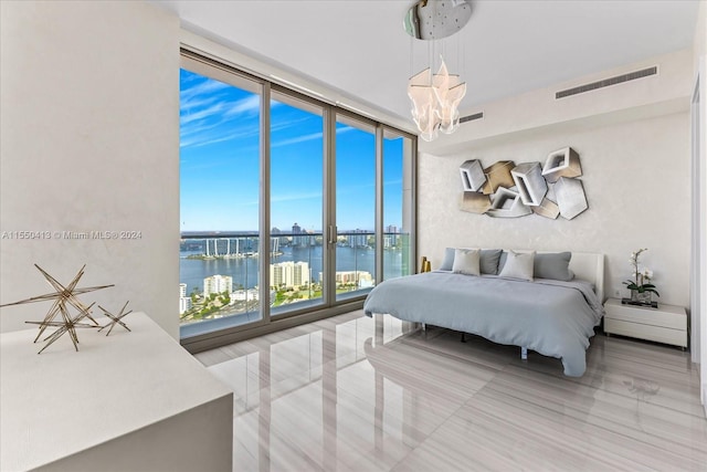 bedroom with a notable chandelier, a water view, expansive windows, and light tile floors