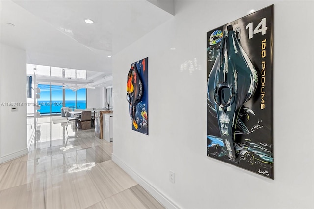 hall featuring light tile flooring and floor to ceiling windows