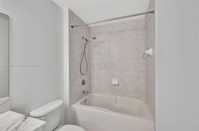 full bathroom with toilet, vanity, and tiled shower / bath