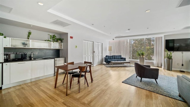 dining room with sink and light hardwood / wood-style flooring