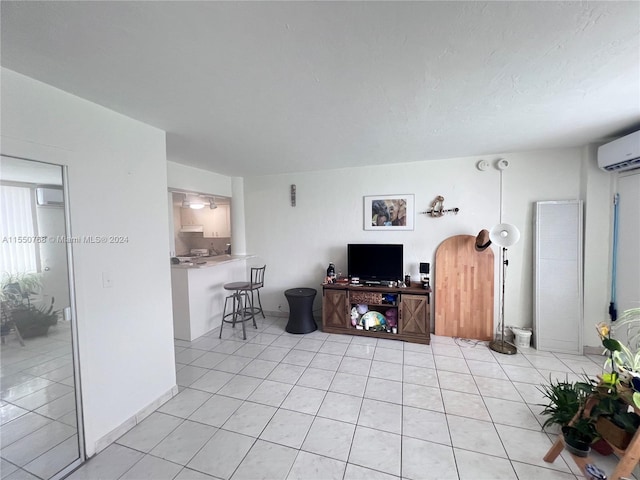 living room featuring a wall mounted air conditioner and light tile floors