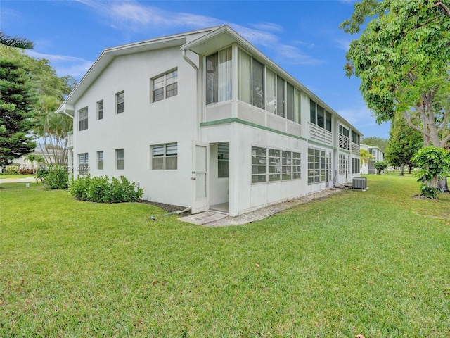 back of house with a yard and central AC