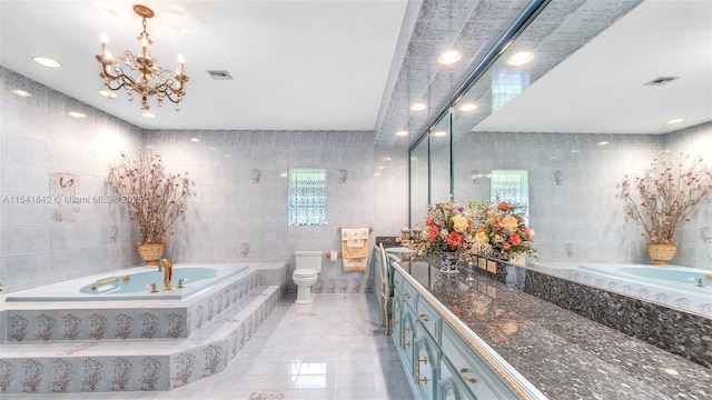 bathroom with toilet, tile patterned flooring, tiled bath, and tile walls