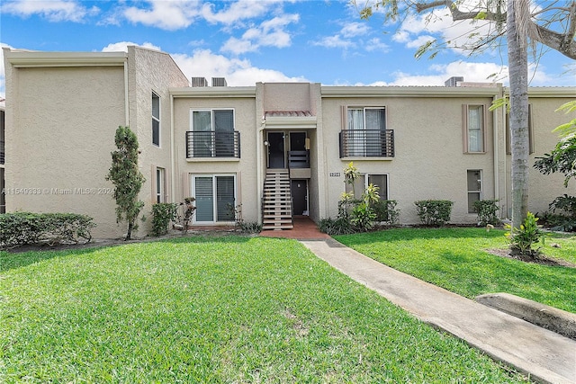 townhome / multi-family property featuring a front lawn