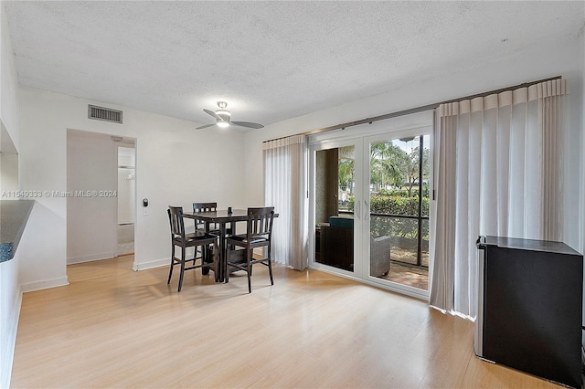 dining room with a textured ceiling, ceiling fan, and light wood-type flooring