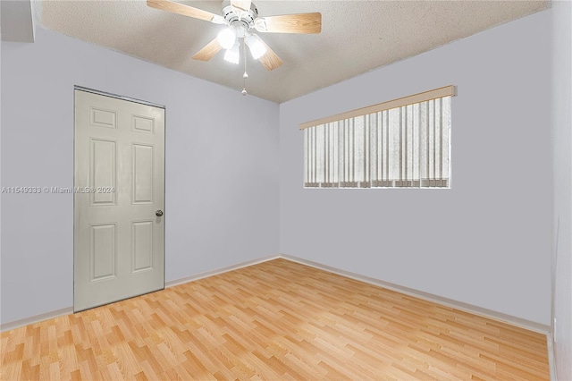 unfurnished room with light hardwood / wood-style flooring, ceiling fan, and a textured ceiling