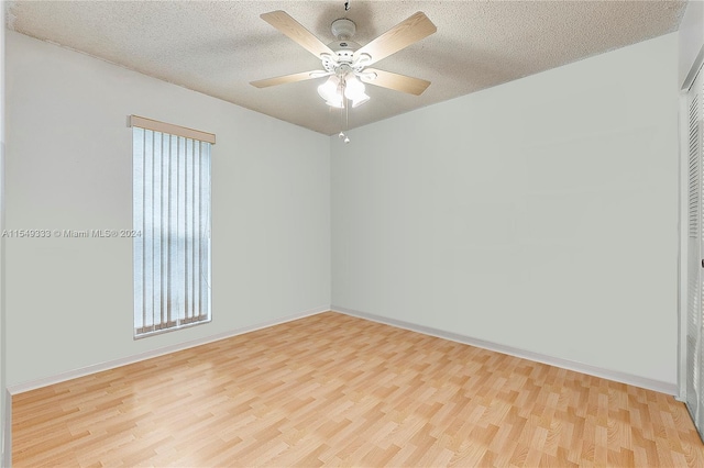 empty room featuring light hardwood / wood-style flooring, ceiling fan, and a textured ceiling