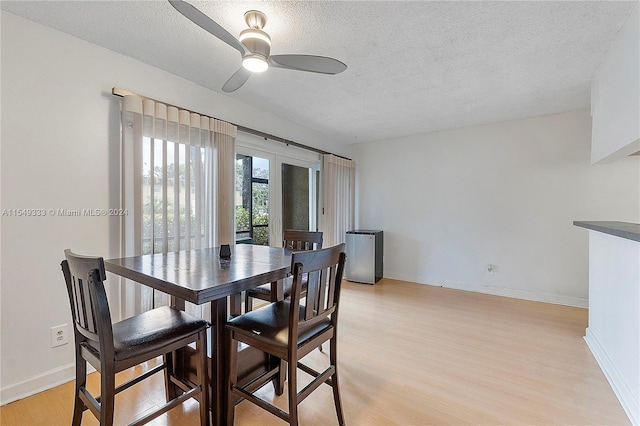 dining space featuring a textured ceiling, ceiling fan, and light hardwood / wood-style floors