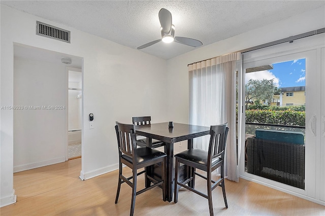 dining space featuring ceiling fan, a textured ceiling, and light wood-type flooring