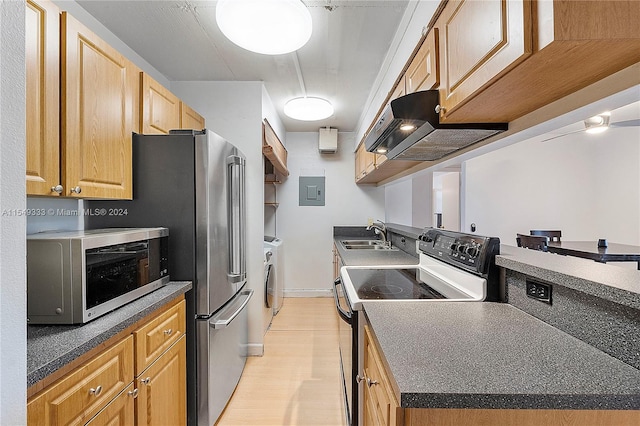 kitchen featuring custom exhaust hood, electric stove, washing machine and clothes dryer, sink, and light hardwood / wood-style floors