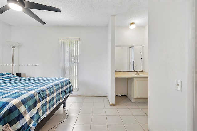 bedroom with sink, ceiling fan, light tile floors, and a textured ceiling