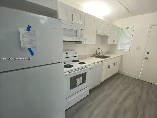 kitchen with hardwood / wood-style floors, sink, white appliances, and white cabinetry