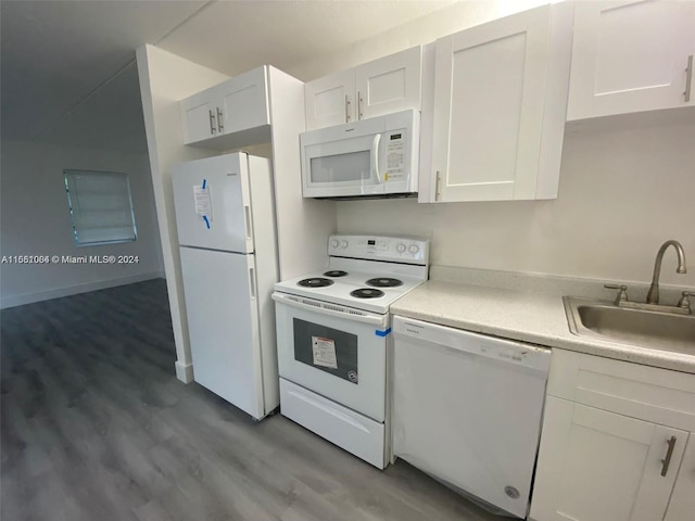 kitchen with white cabinets, sink, white appliances, and hardwood / wood-style flooring