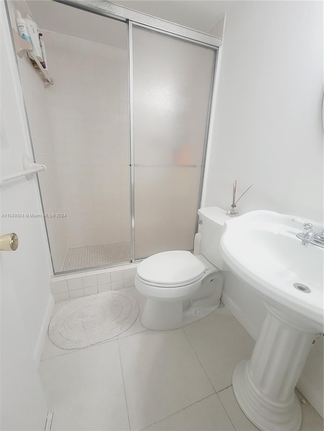 bathroom with walk in shower, toilet, and tile floors